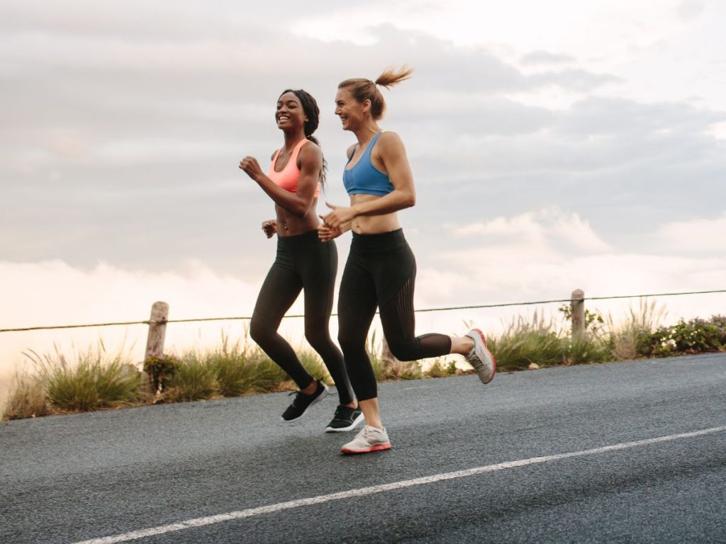 Two runners - presumably recovered from Achilles tendinopathy - running on a relatively flat road