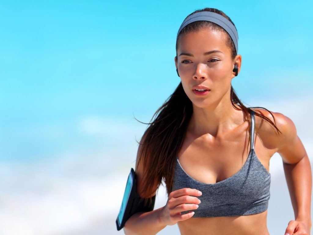 A runner listen to music on her run. Fast paced music has been shown to improve running performance.