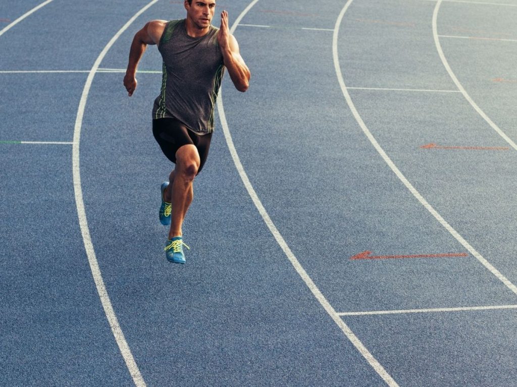 A runner performing a speed interval on a track to get faster